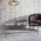 Table basse avec plateau en verre biseauté et piètement en métal bronze