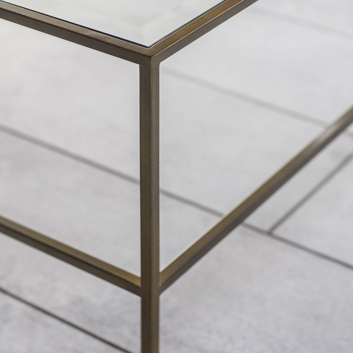 Table basse avec plateau en verre biseauté et piètement en métal bronze